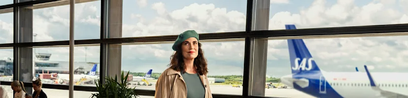 Woman walking in airport with carry-on bag